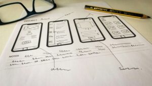 whiteboard with app concept sketches and sticky notes to validate mobile app ideas